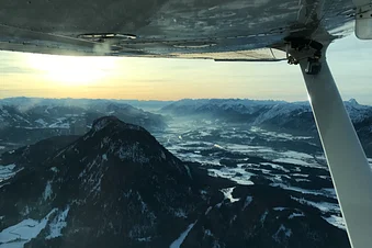 Rückflug über den Alpen mit Sonnenuntergang