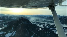 Rückflug über den Alpen mit Sonnenuntergang