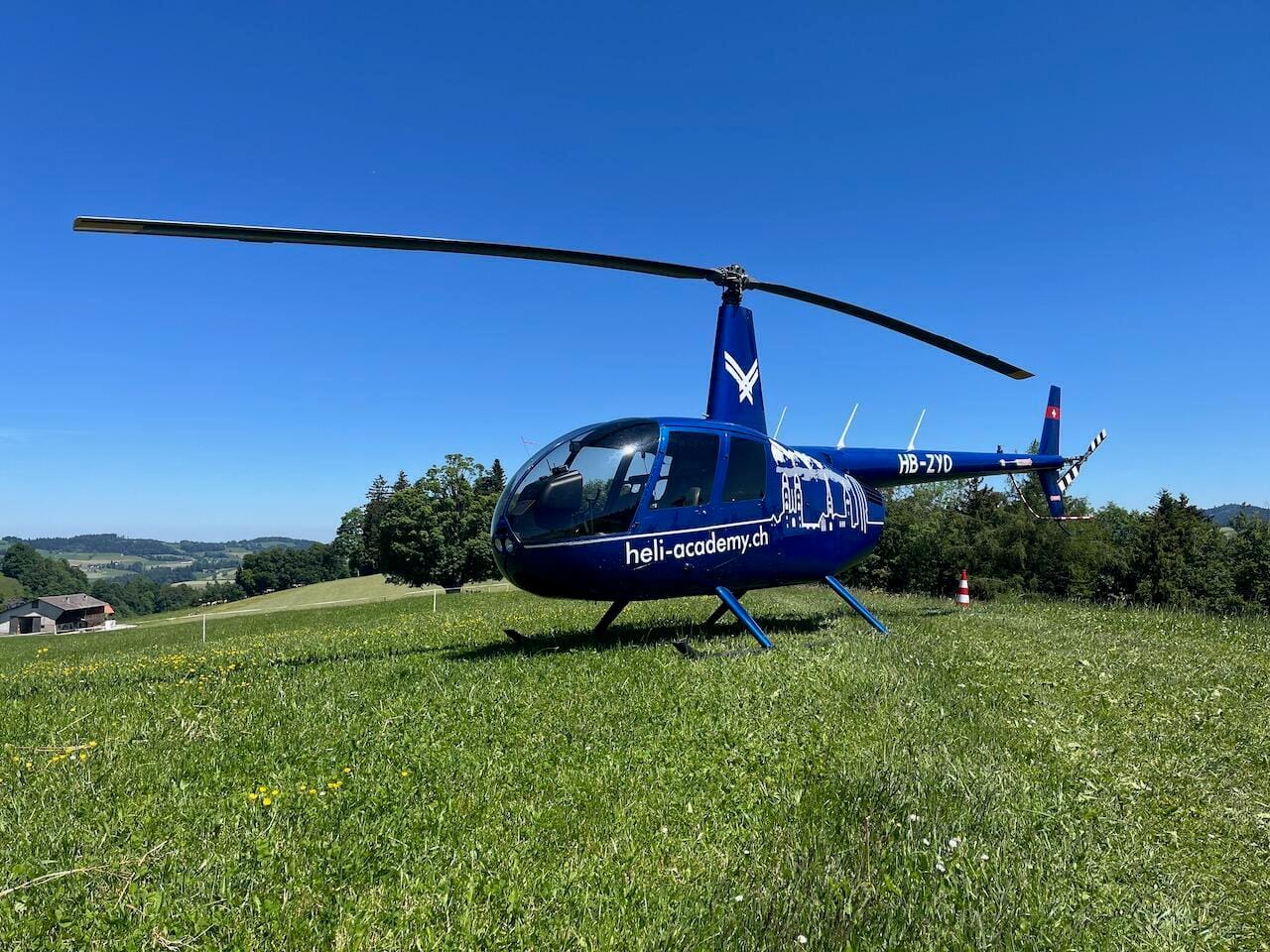 Robinson R44 Raven II auf einer Wiese beim Restaurant Weid-Hof in Oberhelfenschwil