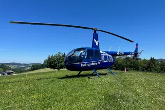 Robinson R44 Raven II auf einer Wiese beim Restaurant Weid-Hof in Oberhelfenschwil