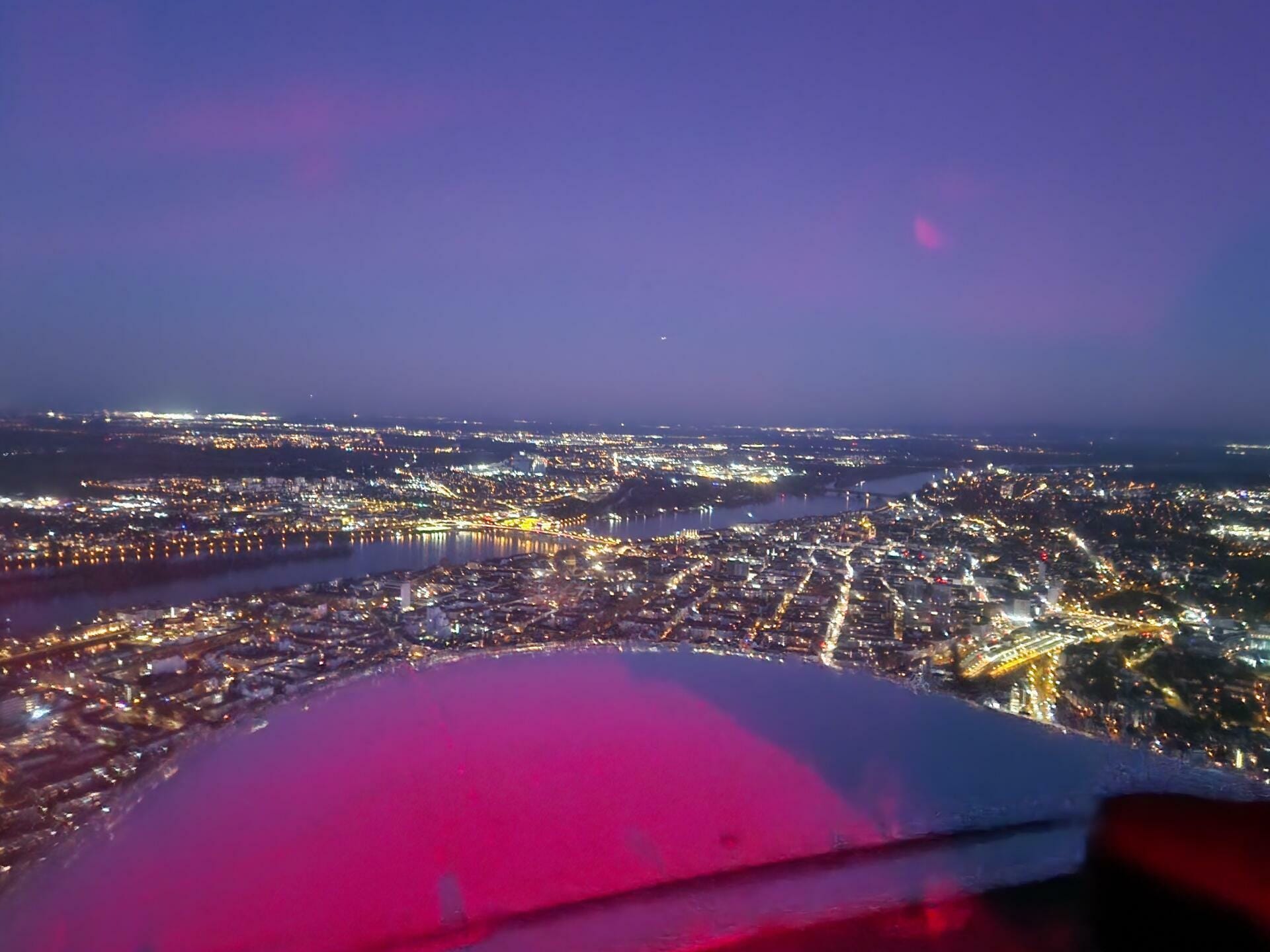 Über Mainz mit dem leuchtenden Frankfurter Flughafen am Horizont