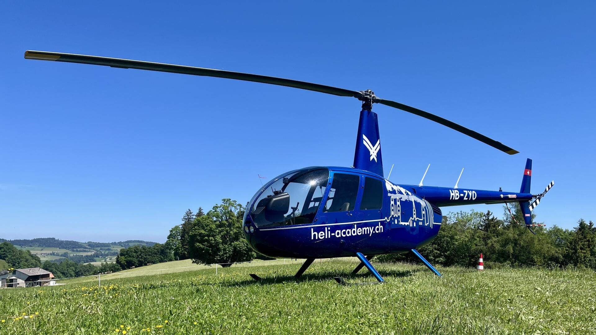 Robinson R44 Raven II von schräg vorne auf einer Wiese