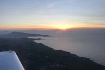 Vol coucher du soleil vers la côte