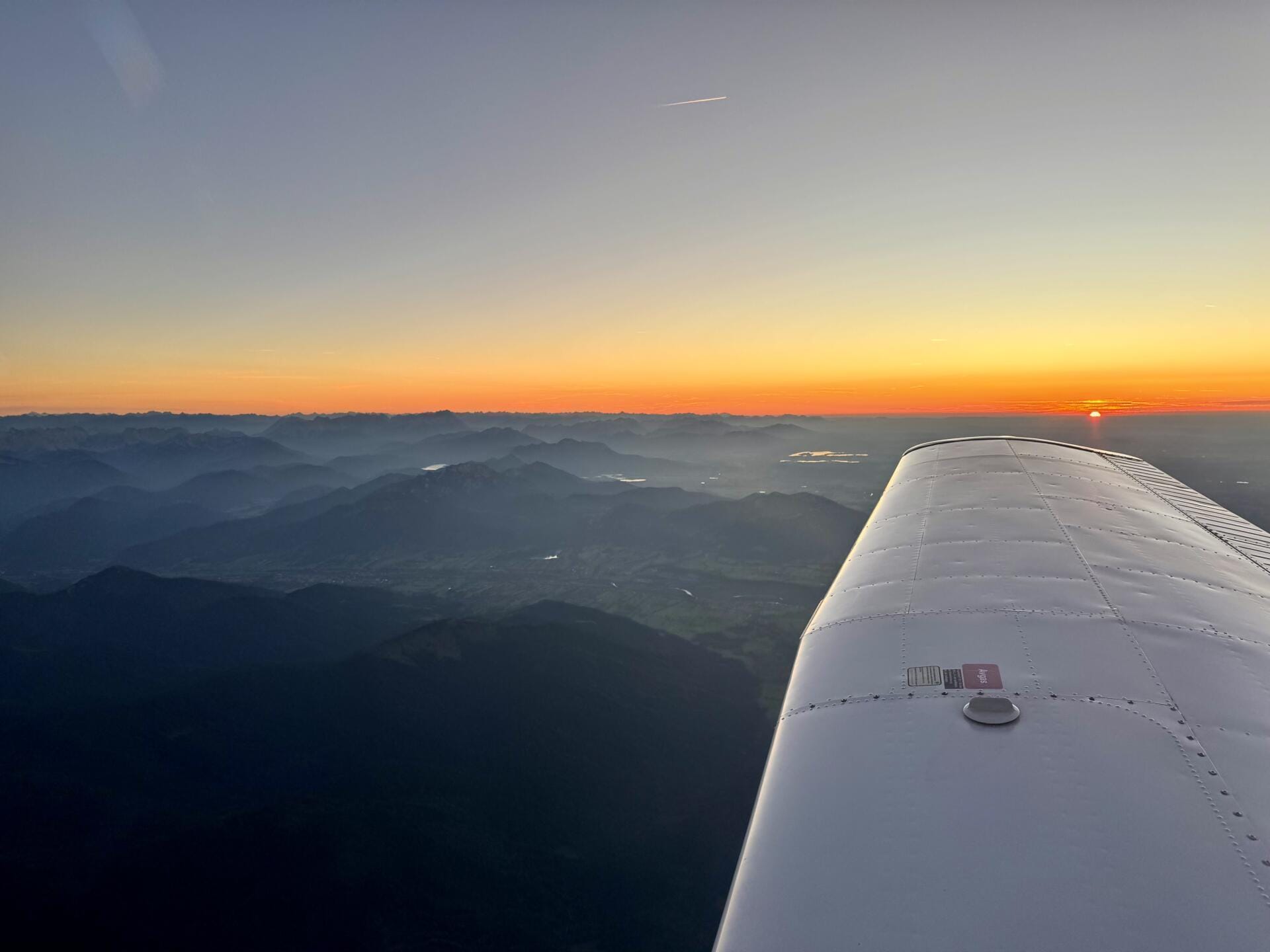 Anflug auf die Alpen bei Sonnenuntergang