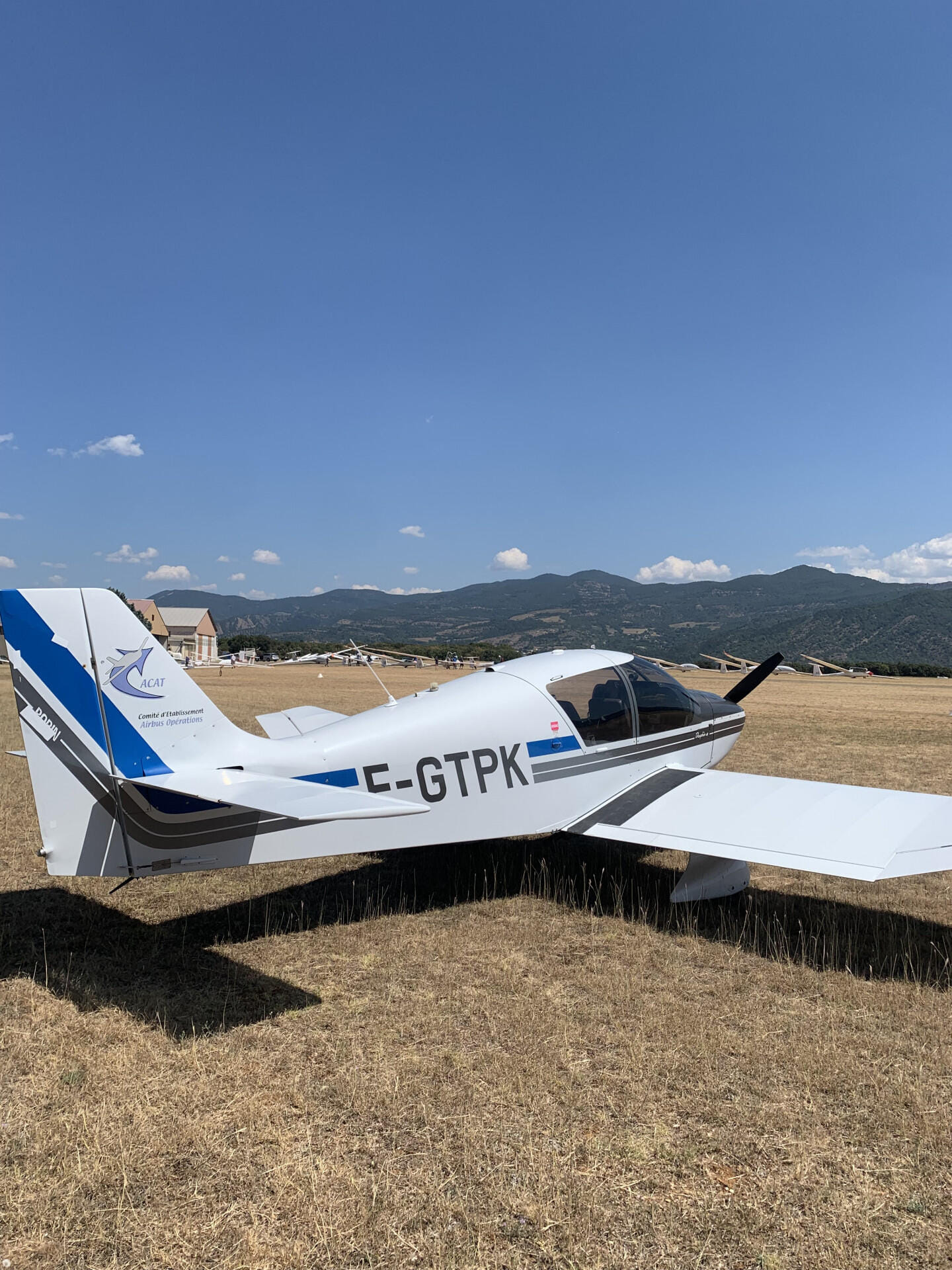 Vue d'ensemble d'un DR400 dans les Alpes