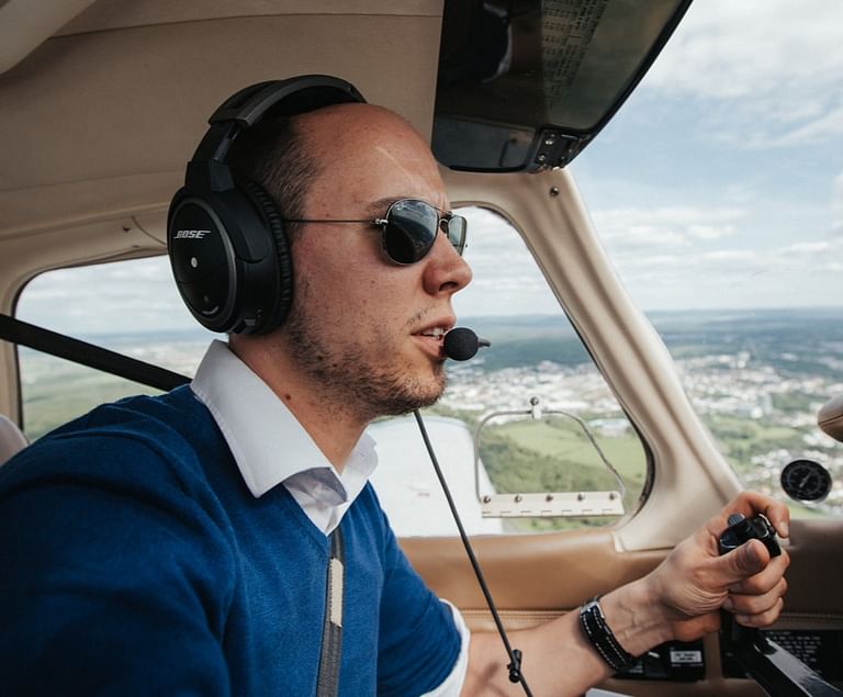 A pilot with a headset flies his plane