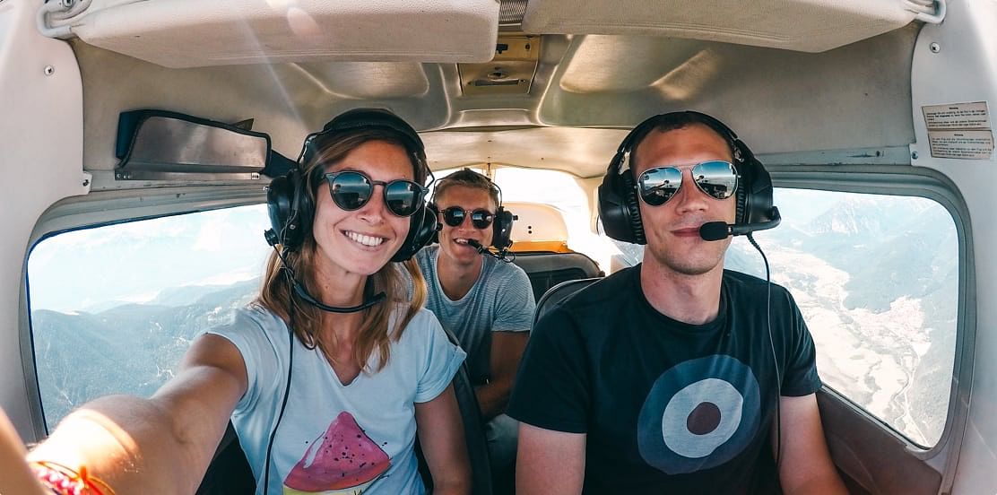 Quatre personnes souriantes dans le cockpit d'un avion léger