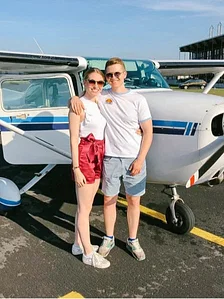 Junges Paar vor Flugzeug