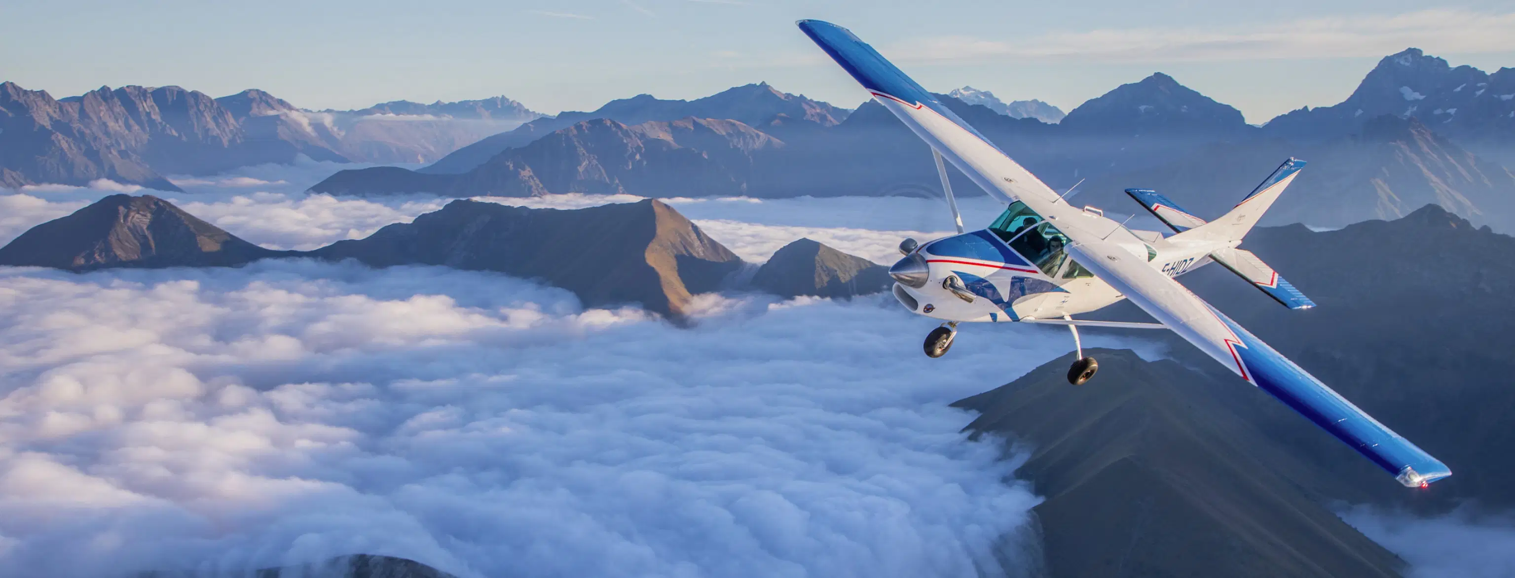 Personen in einem kleinen Flugzeug über den Bergen