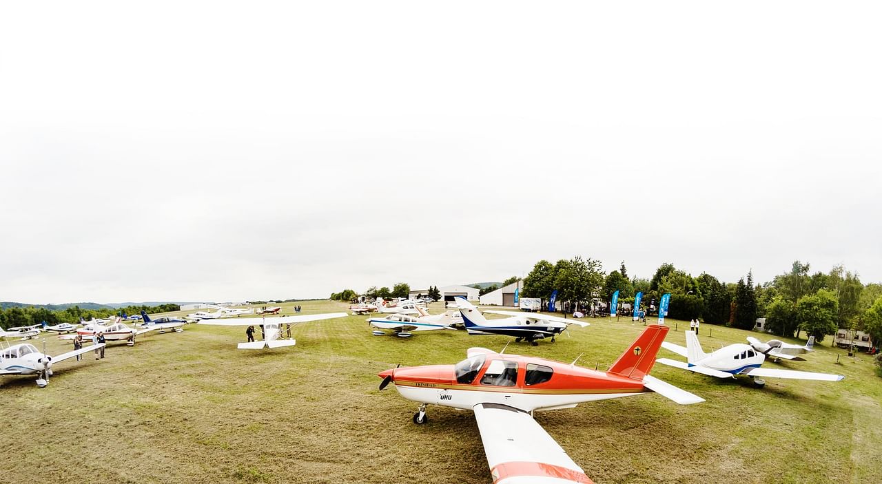 Several light aircraft parked in a field